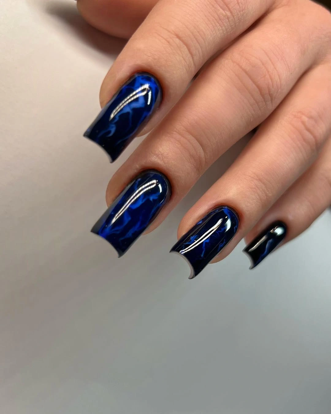 Long cobalt blue coffin nails with curved reflective highlights
