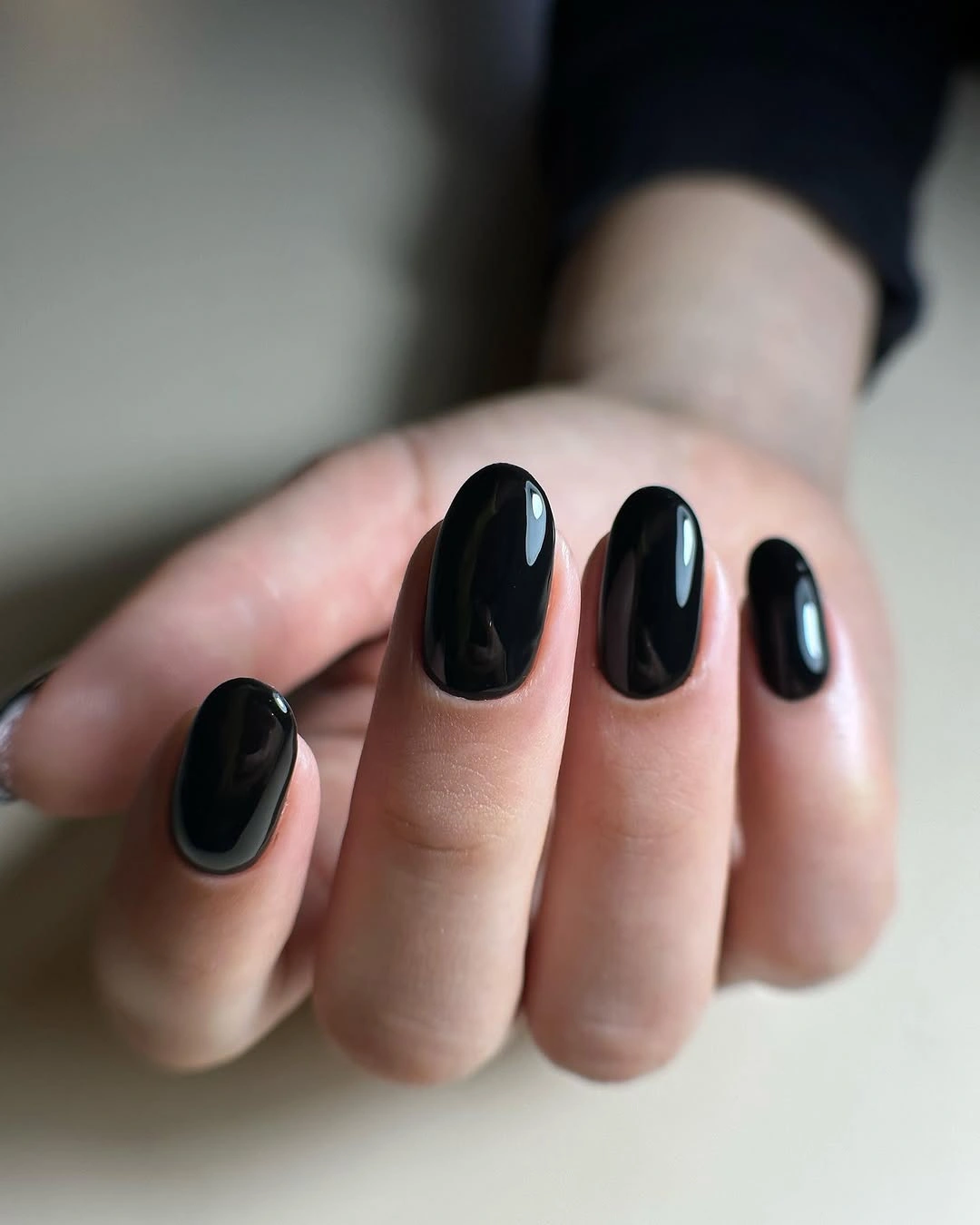Short rounded-square nails in a clean glossy black finish