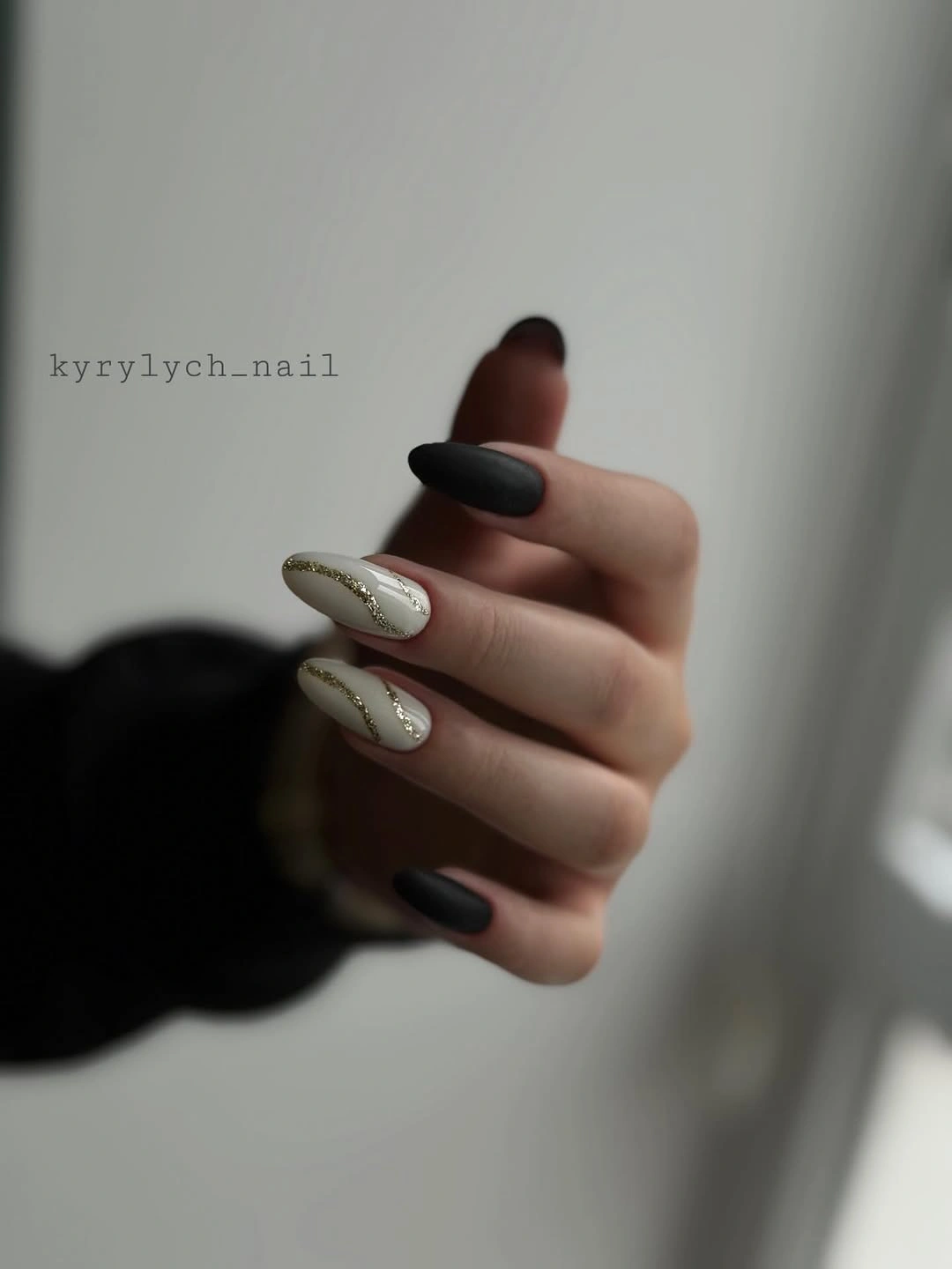 Black almond nails with two pale silver-speckled accent nails