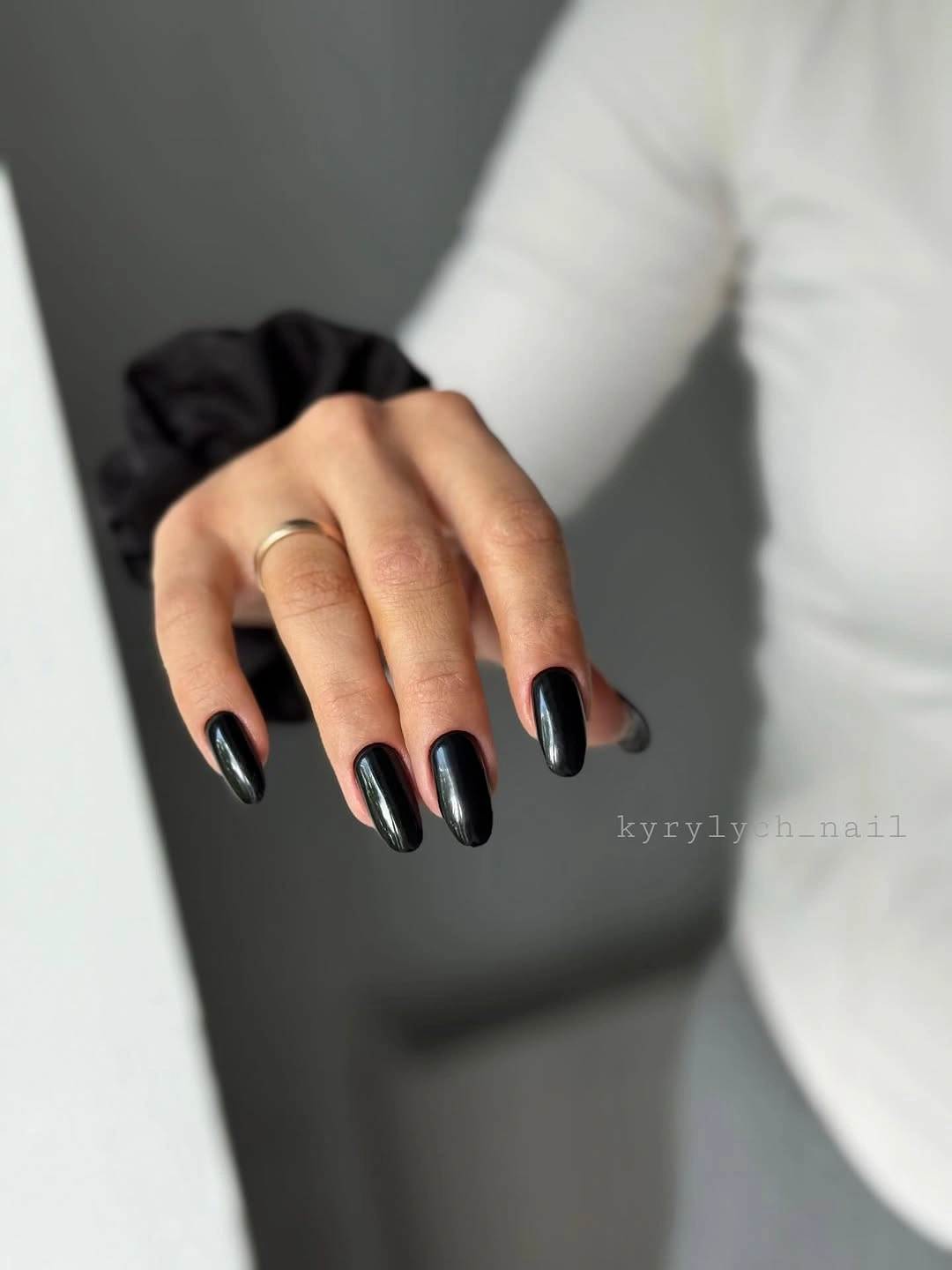 Nearly black almond nails with cool blue-green reflective highlights
