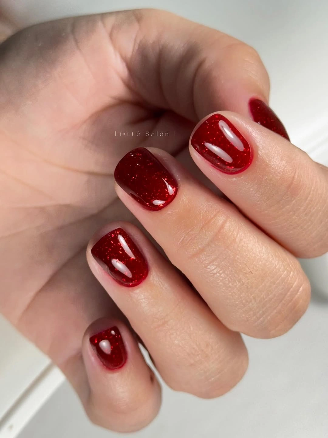Short squoval deep cherry nails with glossy highlights