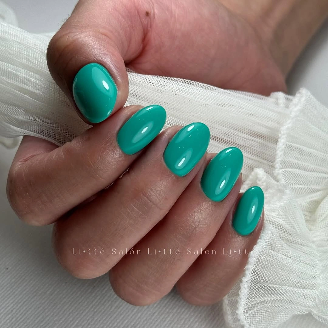 Short almond nails in glossy bright turquoise