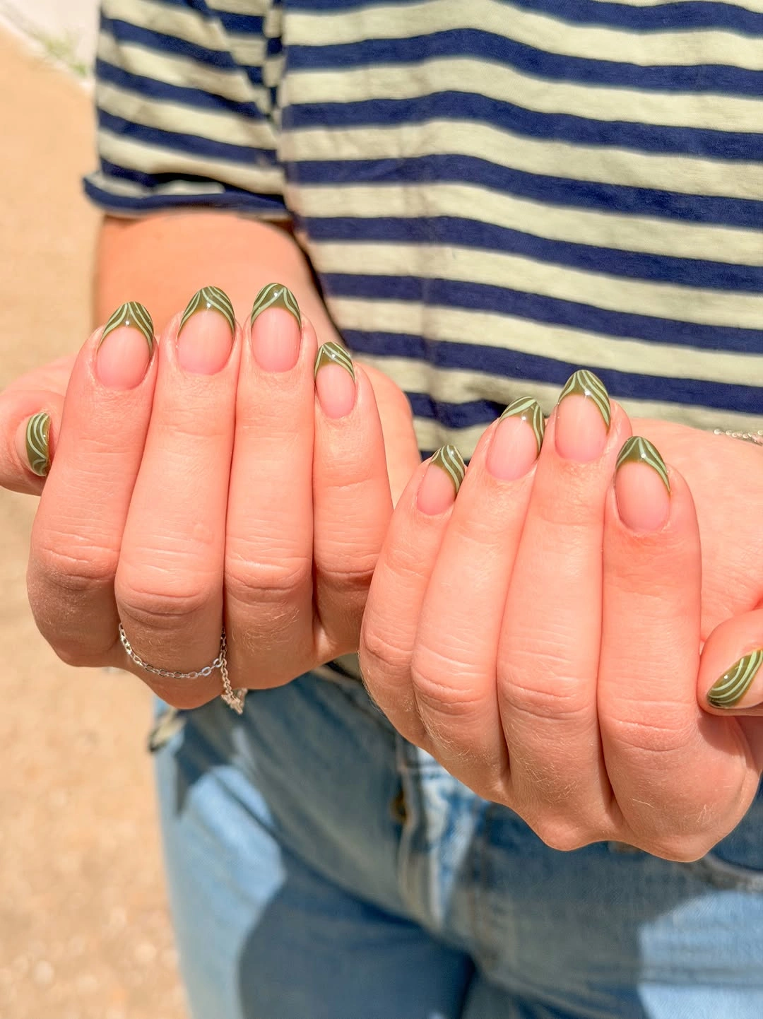 Medium almond nails with lime green outlined French tips and looped curves