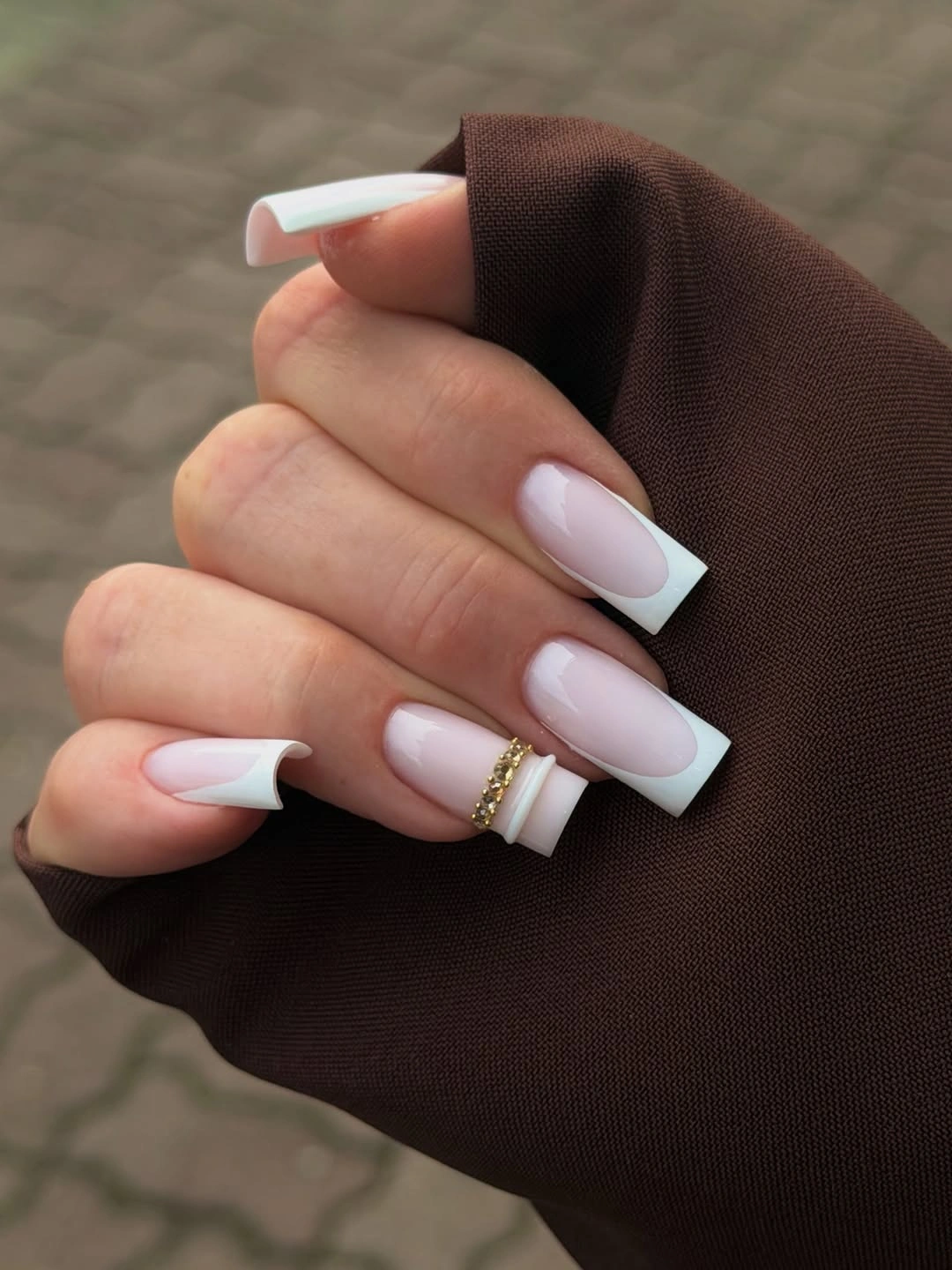 Long square nails with pale pink bases and crisp white French tips