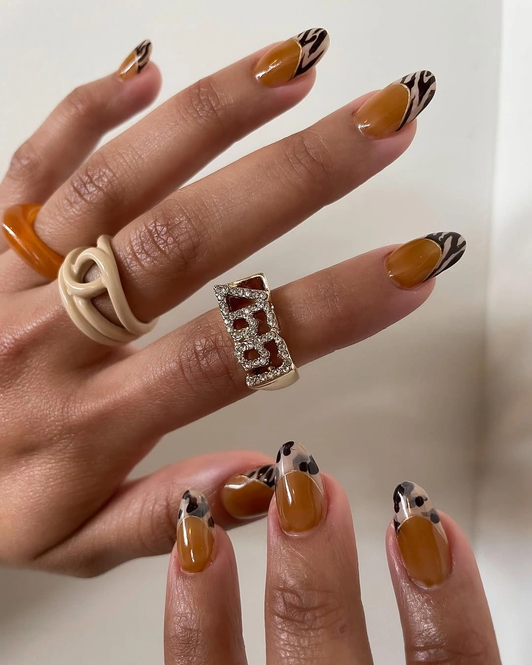 Long almond nails with caramel French and black and white tip details