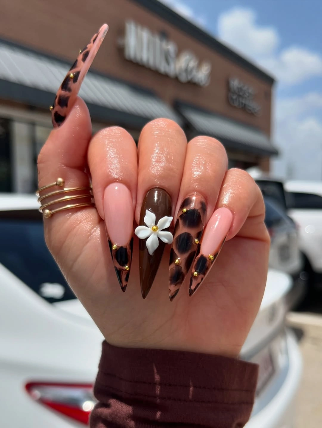 Long stiletto nails with pale pink bases black and burgundy tips and one pale floral accent