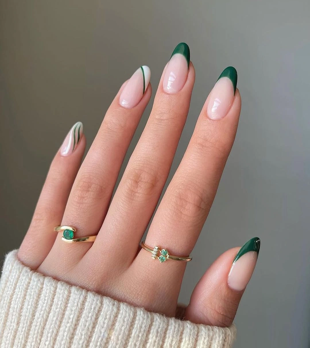 Long almond nails with emerald French edges and fine metallic lines