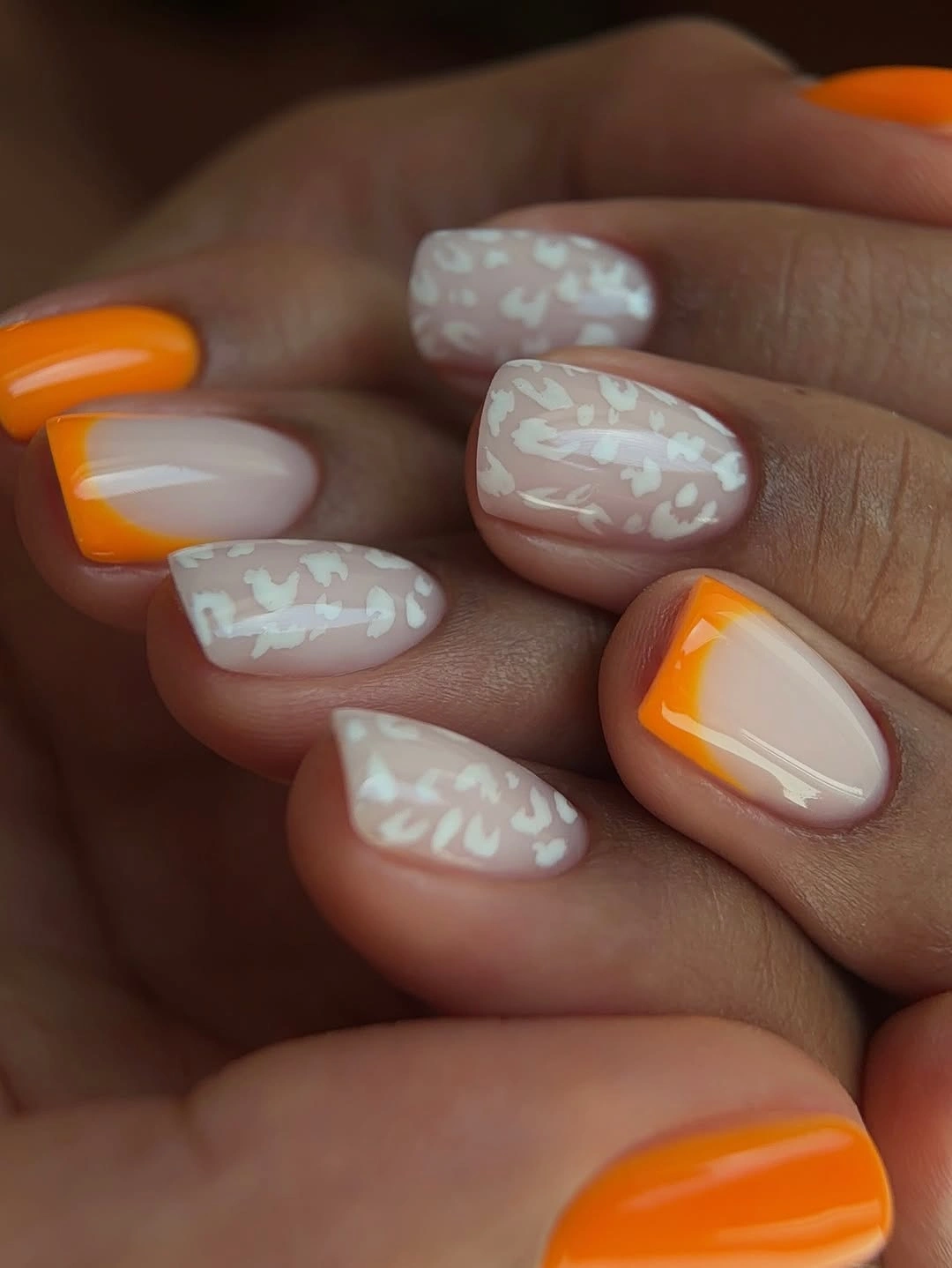 Medium square nails with orange tips and translucent patterned accents
