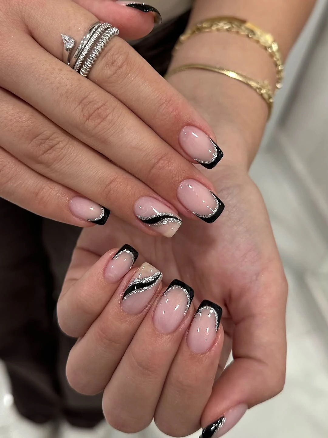 Medium oval nails with black French tips and diagonal line details