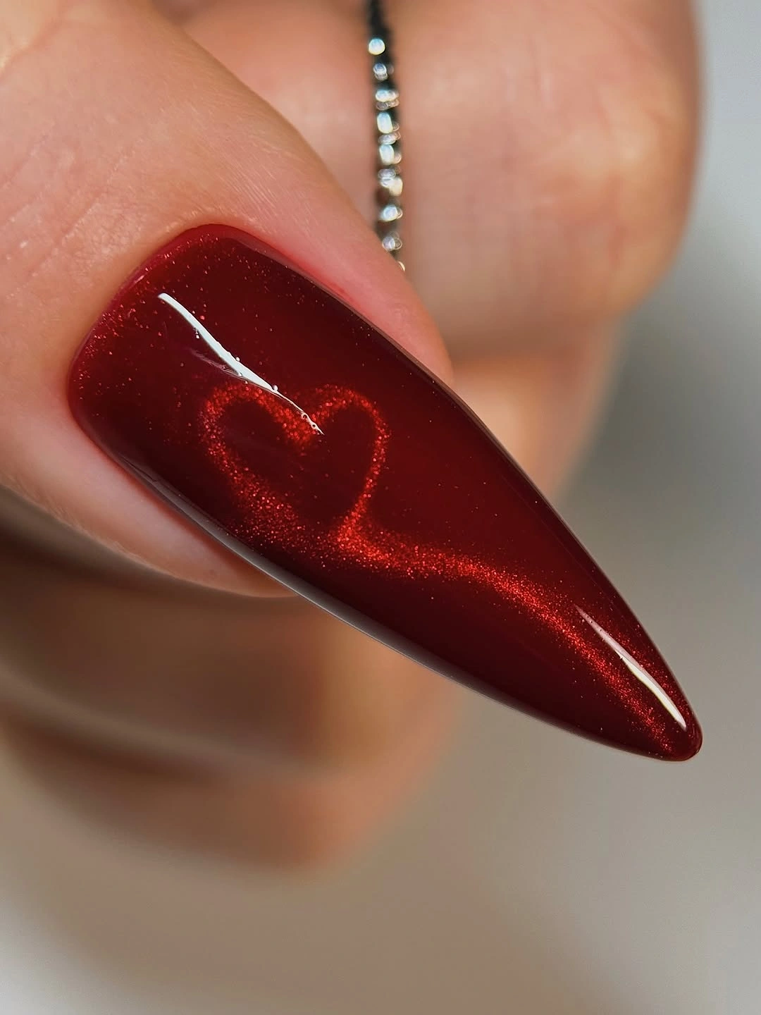 Long pointed red nail with a glittering heart accent