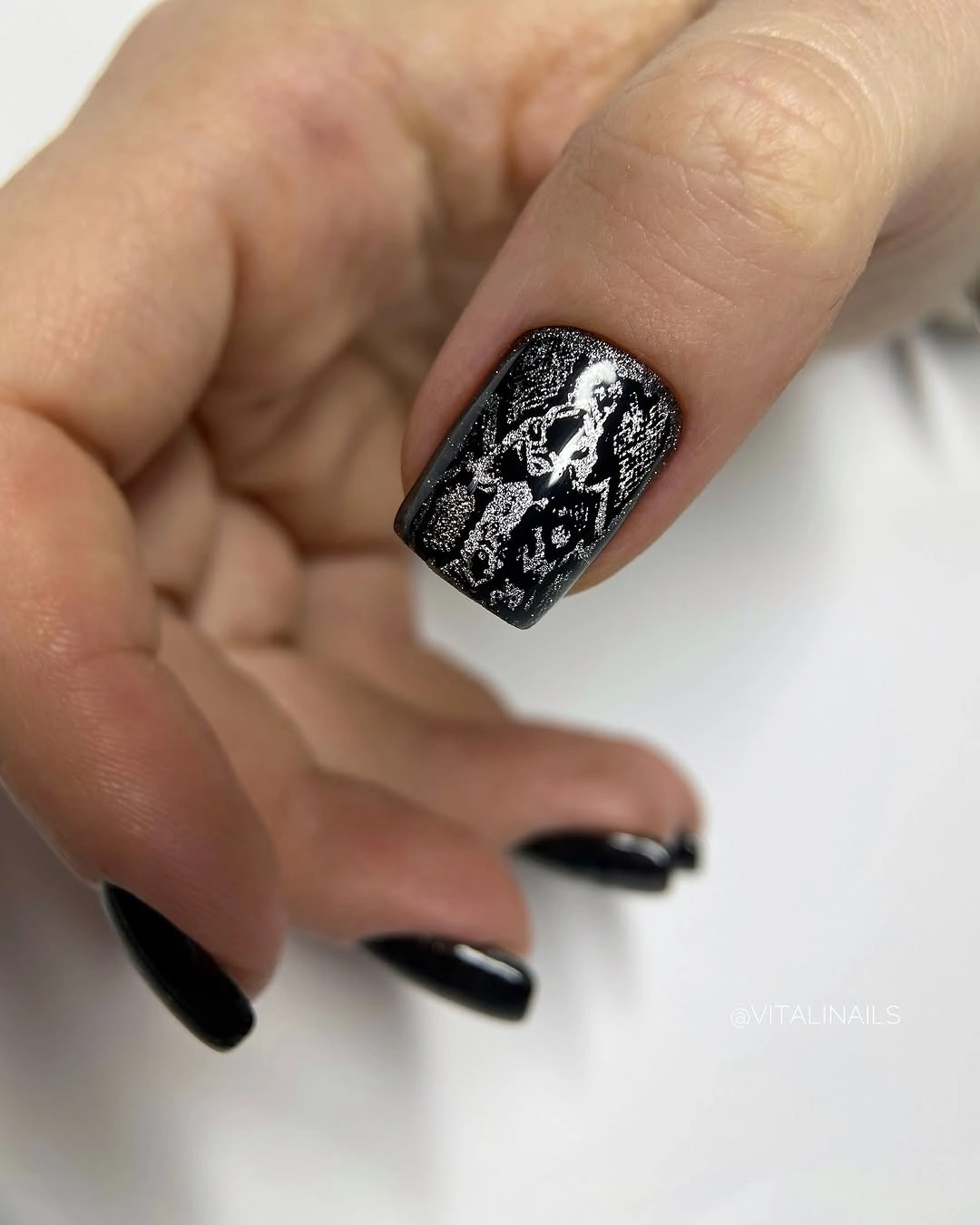 Short black square nails with a dense silver textured accent