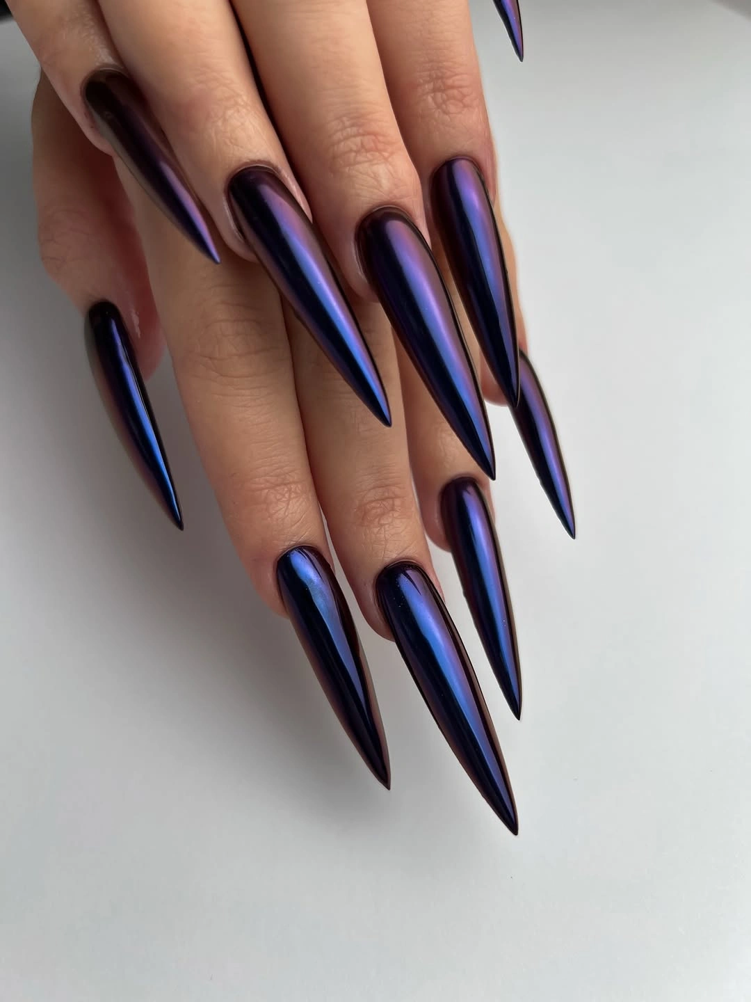 Long black stiletto nails with blue violet reflective highlights