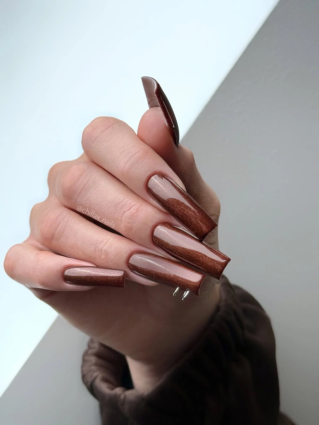 Long square brown nails with darker reflective vertical depth