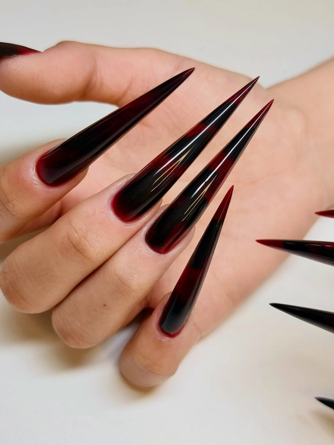 Ultra long black stiletto nails with slim red side edges