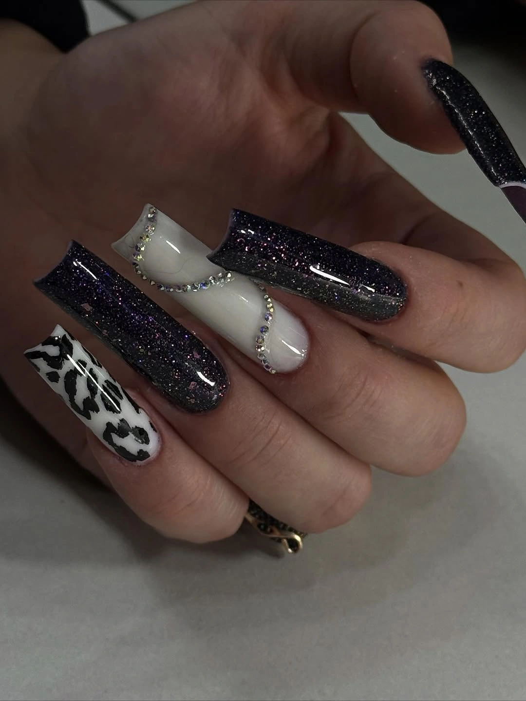 Long black glitter square nails with one white spotted accent