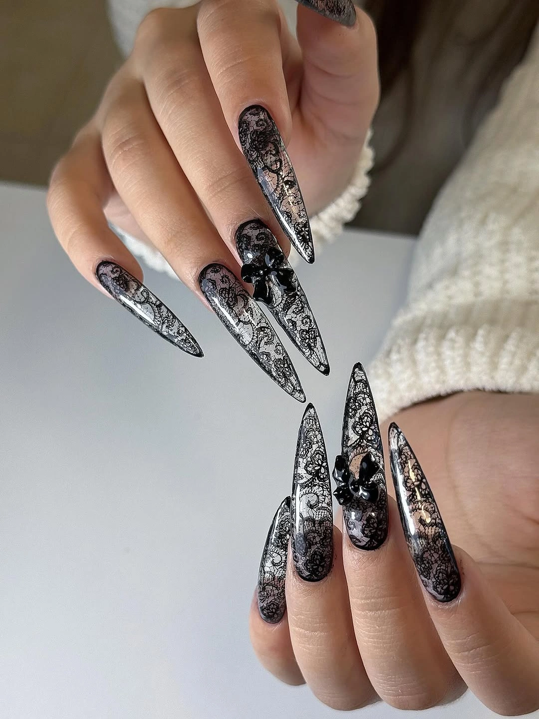 Black and silver ornate stiletto nails with dense decorative detail
