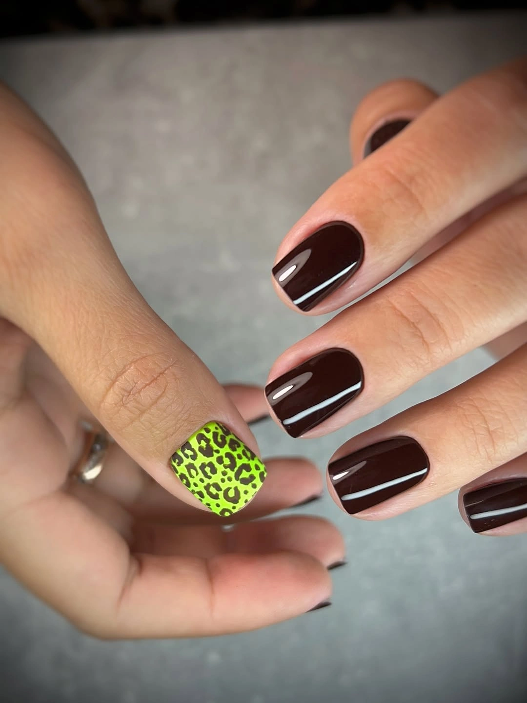 Medium square dark brown nails with one lime spotted accent