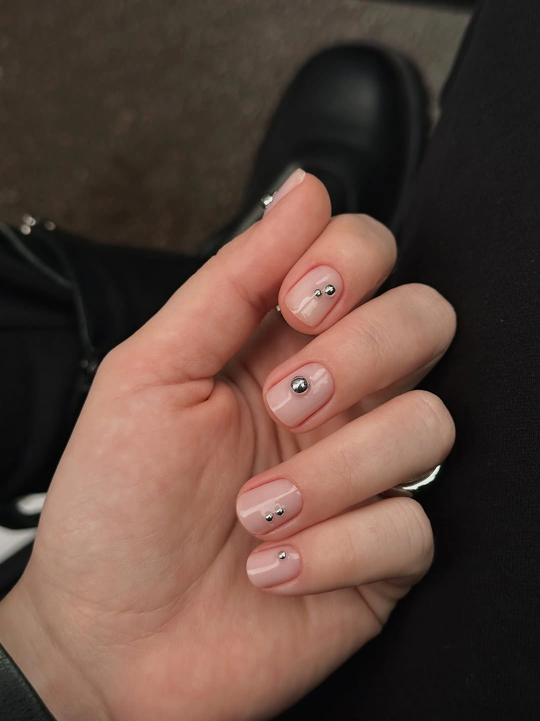 Short oval blush nails with tiny reflective points and dark marks