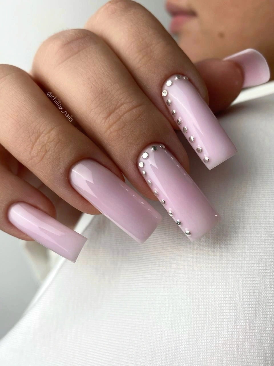 Pale pink square nails with repeated reflective dot accents