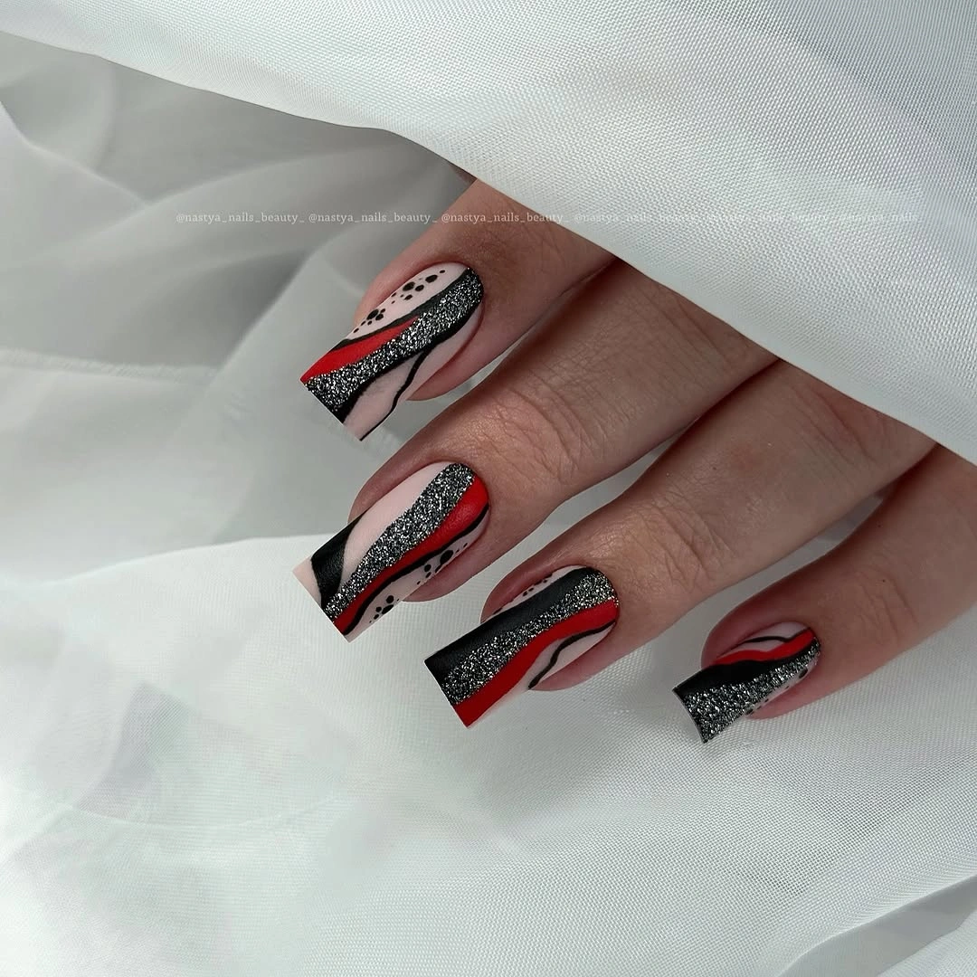 Long square nails with black white patterns and red sweeping curves