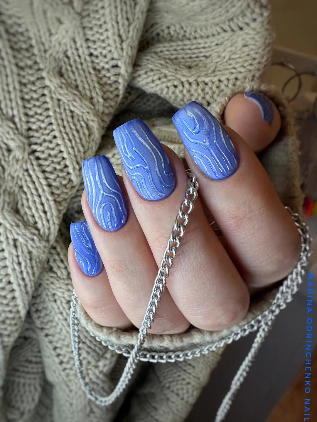 Vivid blue square nails with lighter wavy linework