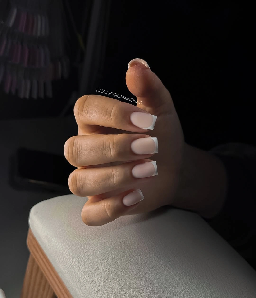 Pale neutral rounded-square nails in deep shadow