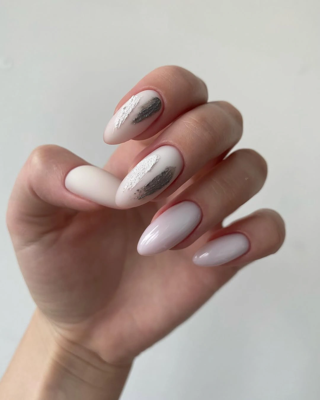 Milky almond nails with sparse silver curved lines