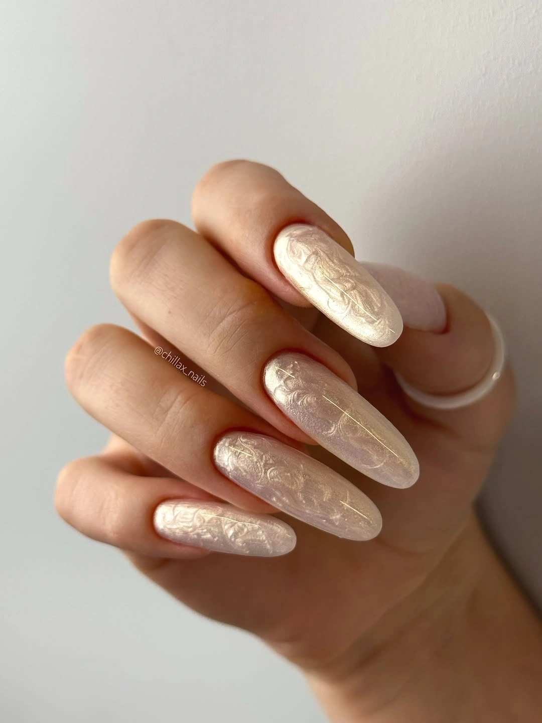 Long almond milky nails with pale pearly lines and soft texture