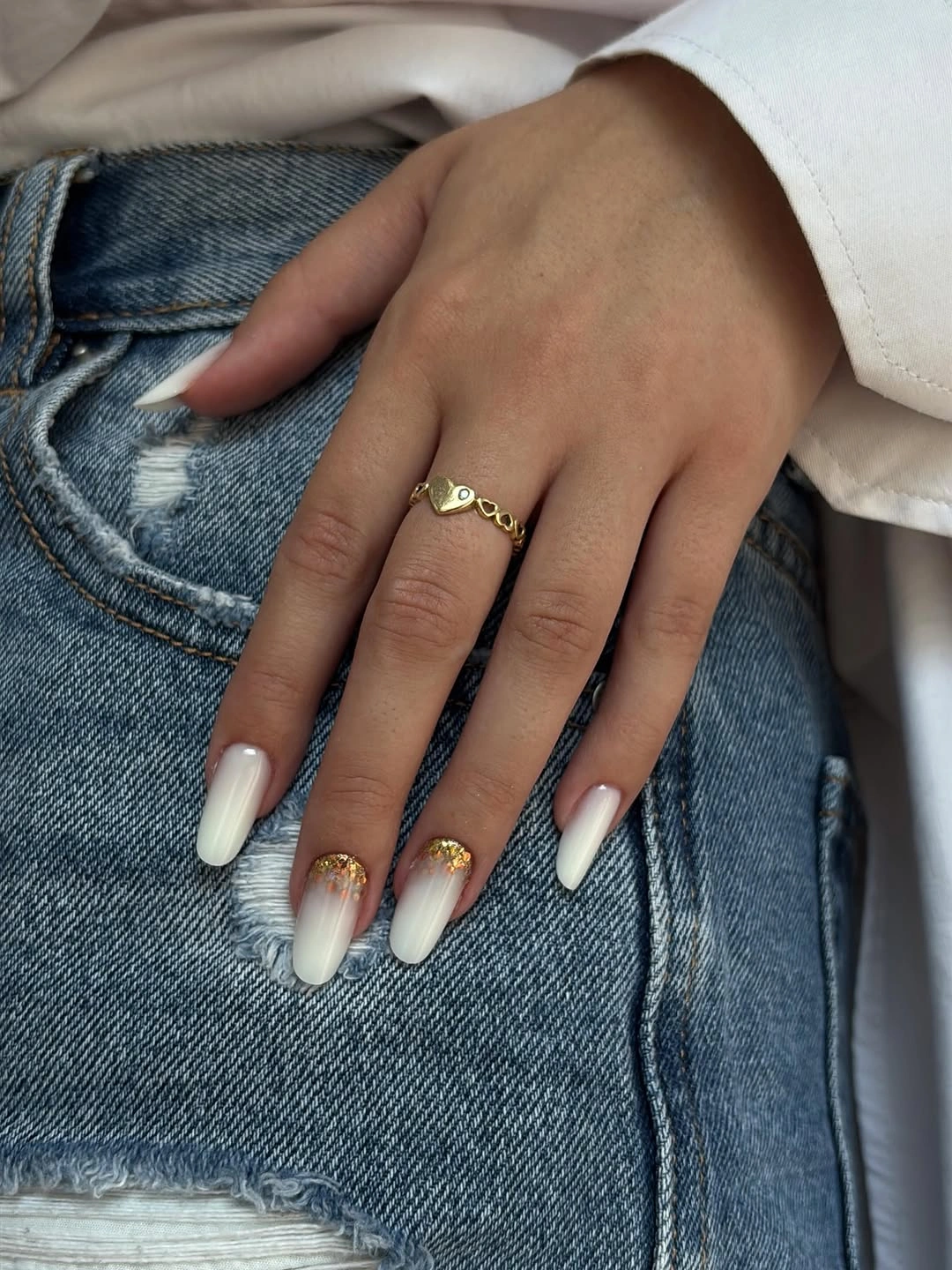Long almond milky nails with pale tips and tiny warm metallic accents