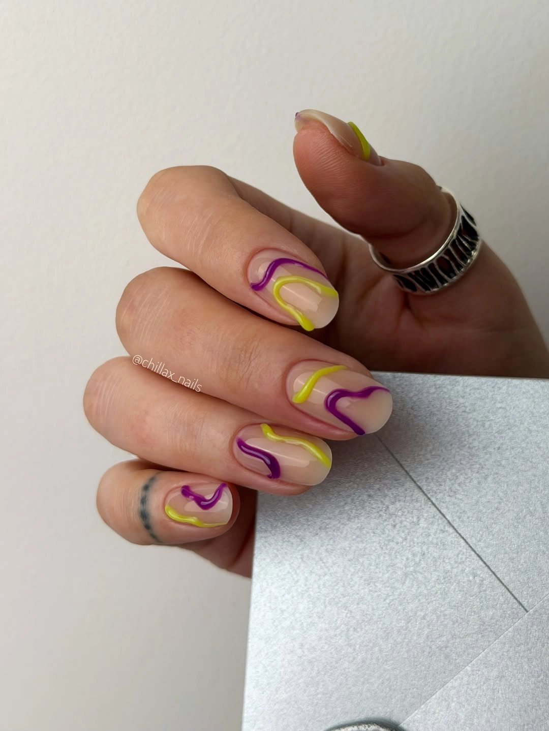 Medium square sheer nude nails with purple and lime loops