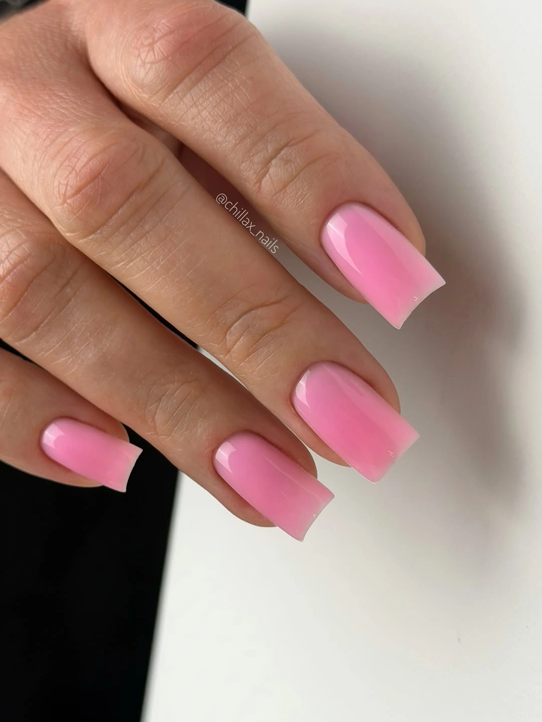 Long square nails painted a uniform glossy hot pink