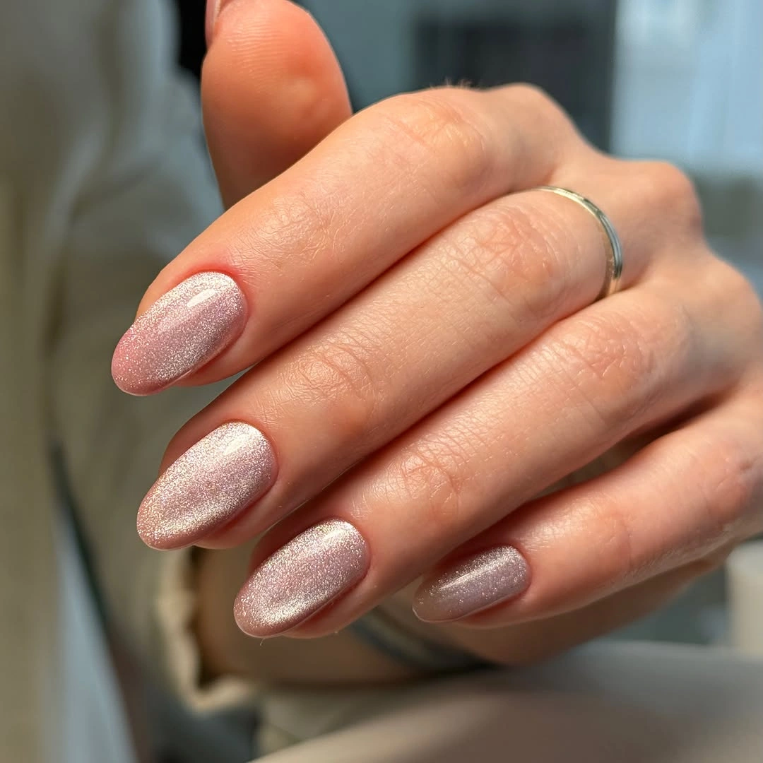 Medium almond nails with a translucent blush base and fine silver-pink shimmer