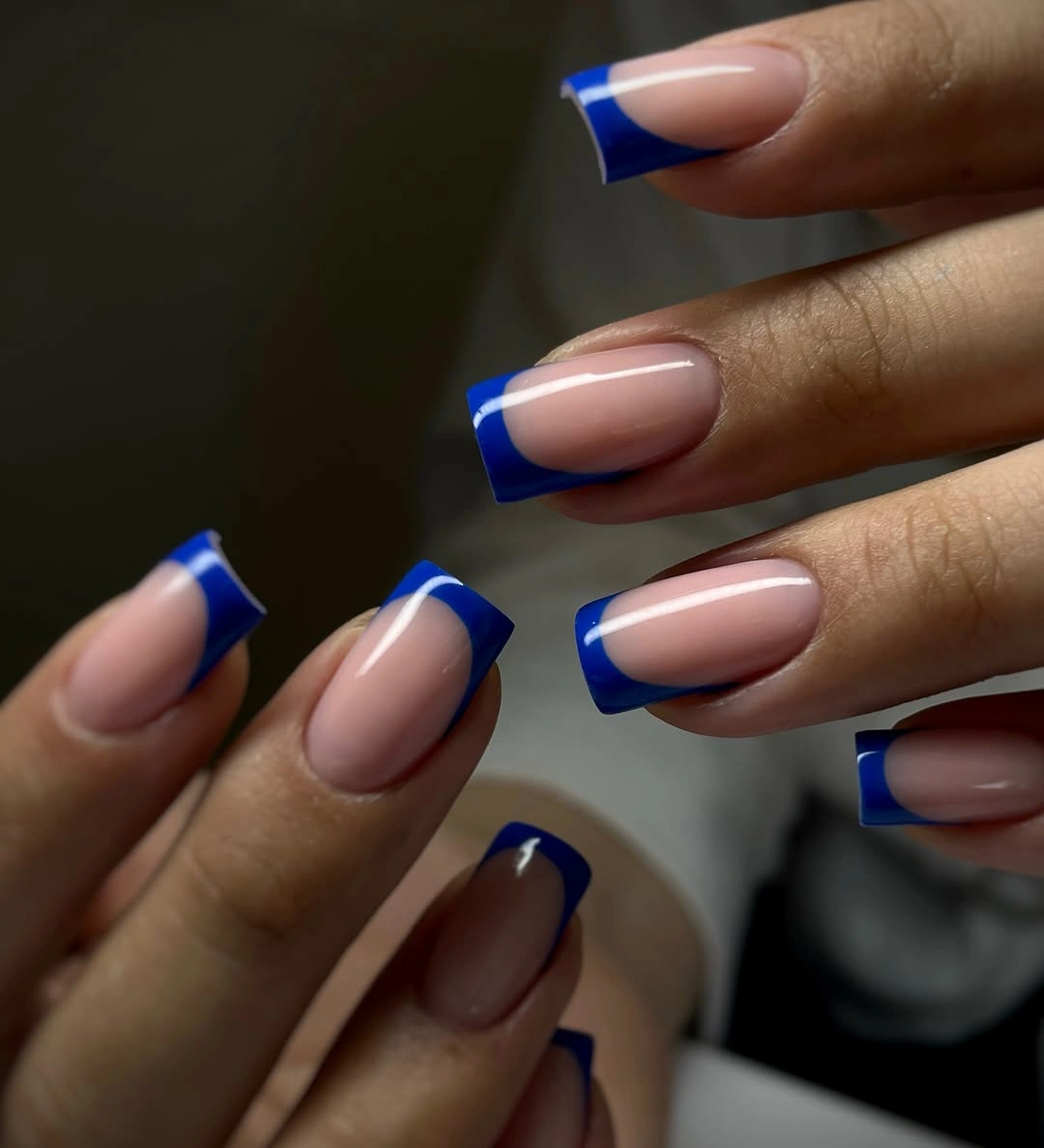 Medium square nails with nude bases and dark cobalt-blue French tips