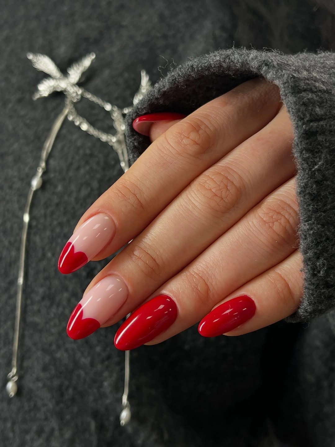 Medium almond nails with pale pink bases and vivid red French tips