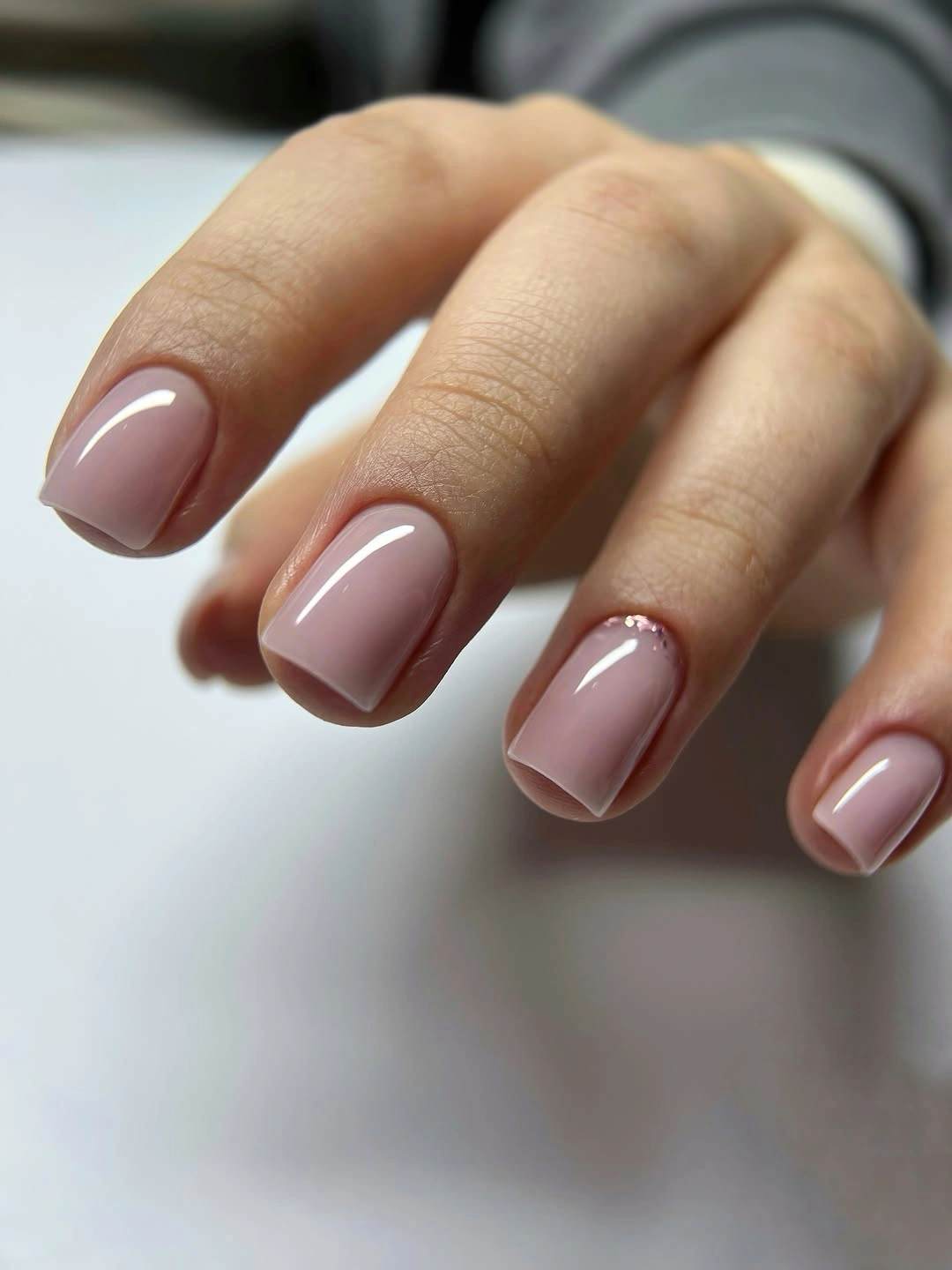 Short rounded-square nails in glossy sheer pink nude