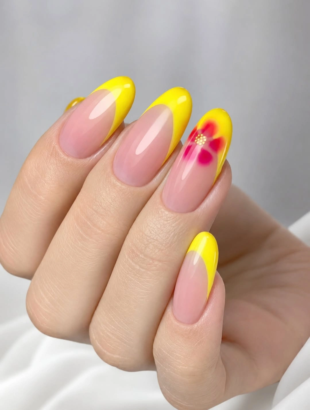 Medium almond nails with translucent pink bases bright yellow tips and pink accent