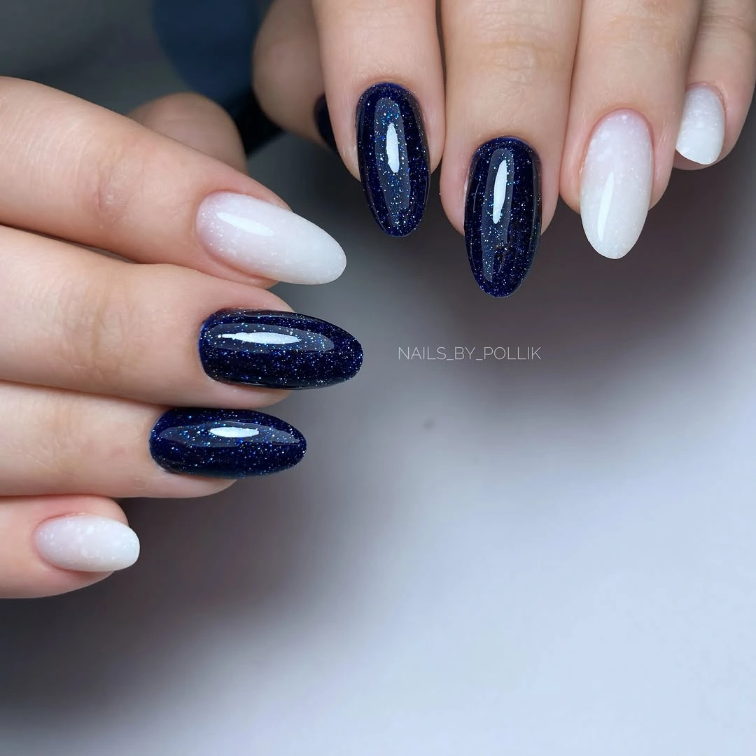 Medium oval nails alternating milky white and deep navy glitter