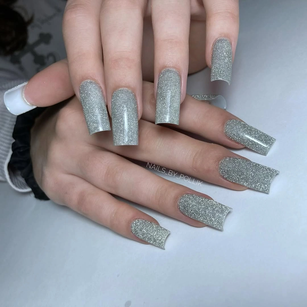 Long square nails covered evenly in bright silver glitter