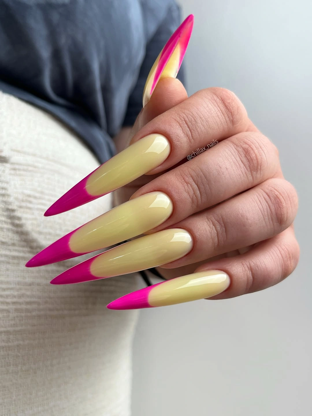 Long stiletto nails with pale yellow centers and magenta pointed tips