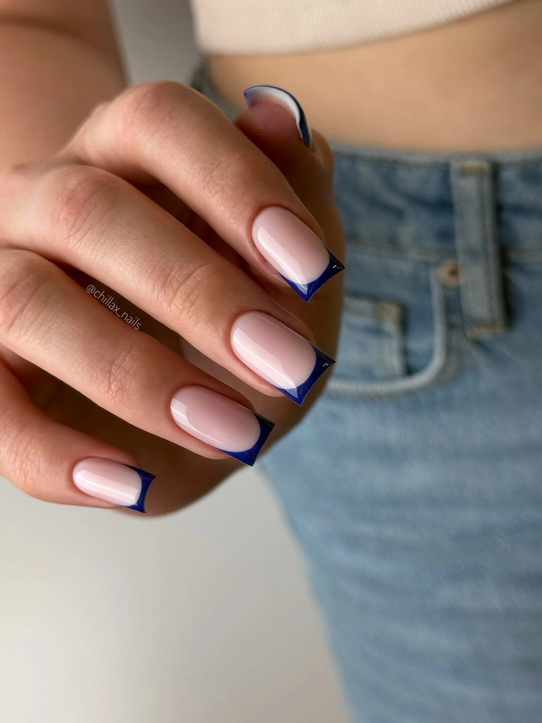 Pale pink square nails with thin dark blue French-style edges