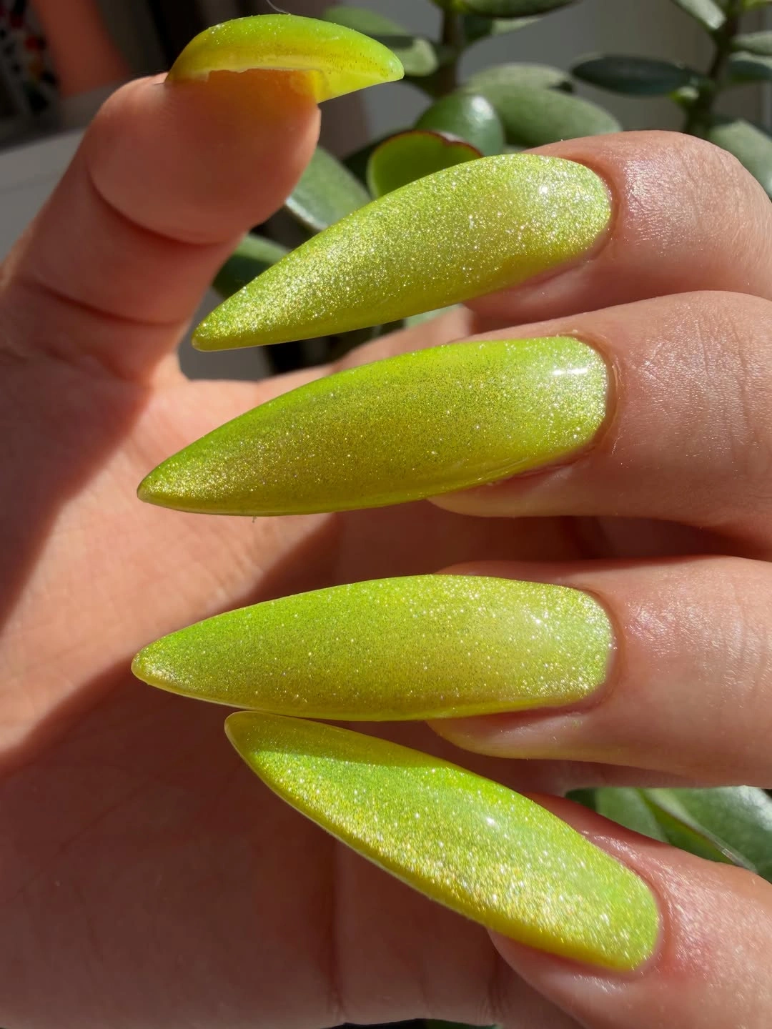 Long almond lime-green nails with a fine reflective shimmer finish