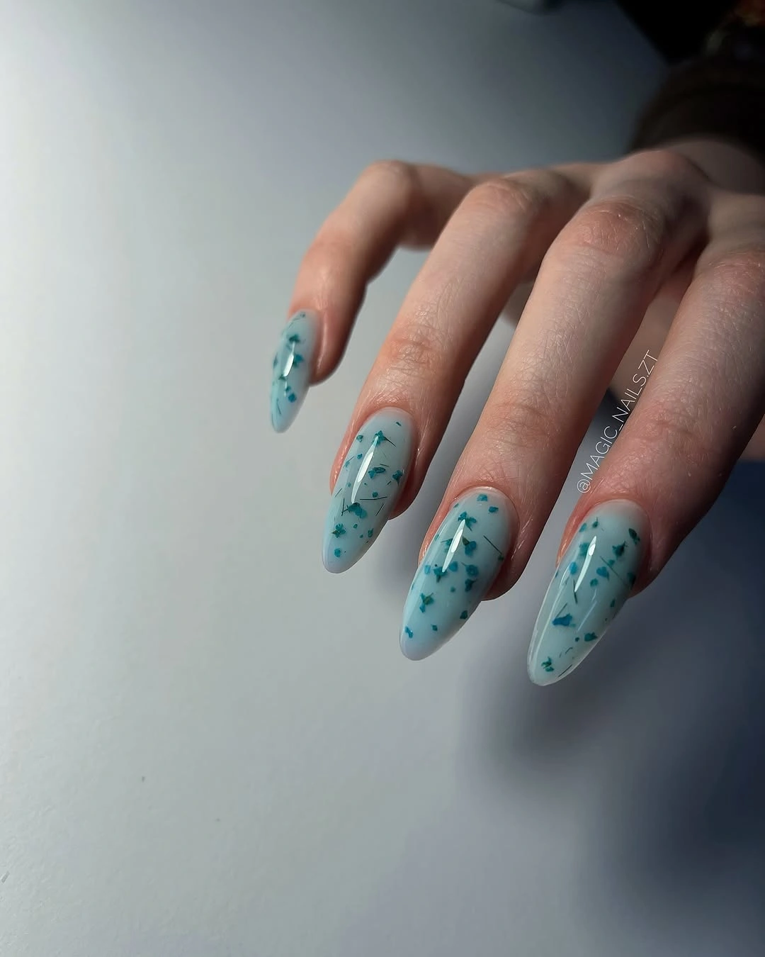 milky aqua almond nails with teal speckled details