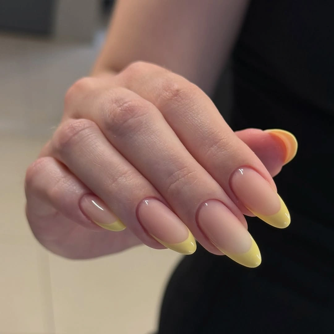 oval nude nails with soft yellow French tips