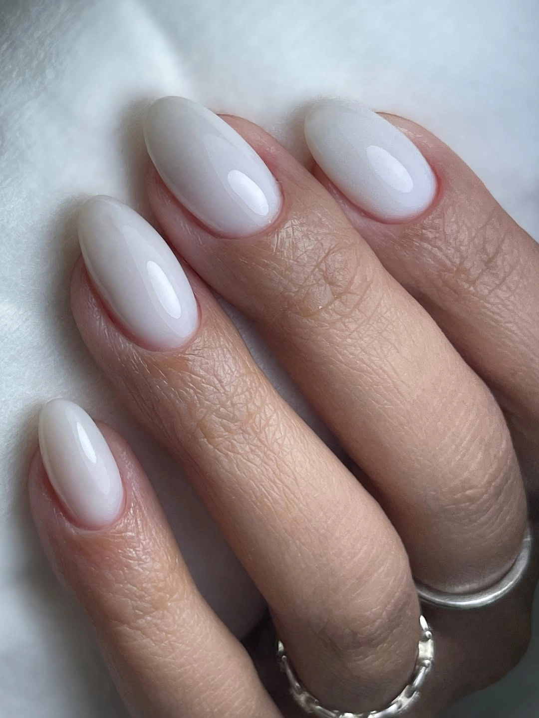 Short rounded-square nails with a solid glossy milky white finish