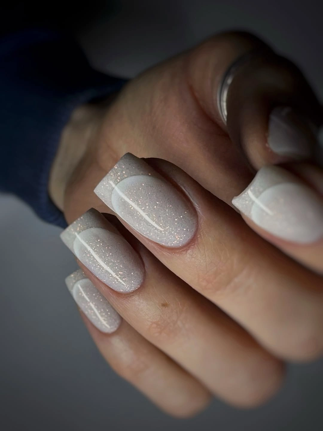 Medium square nails with a translucent white base pale tips and fine silver sparkle