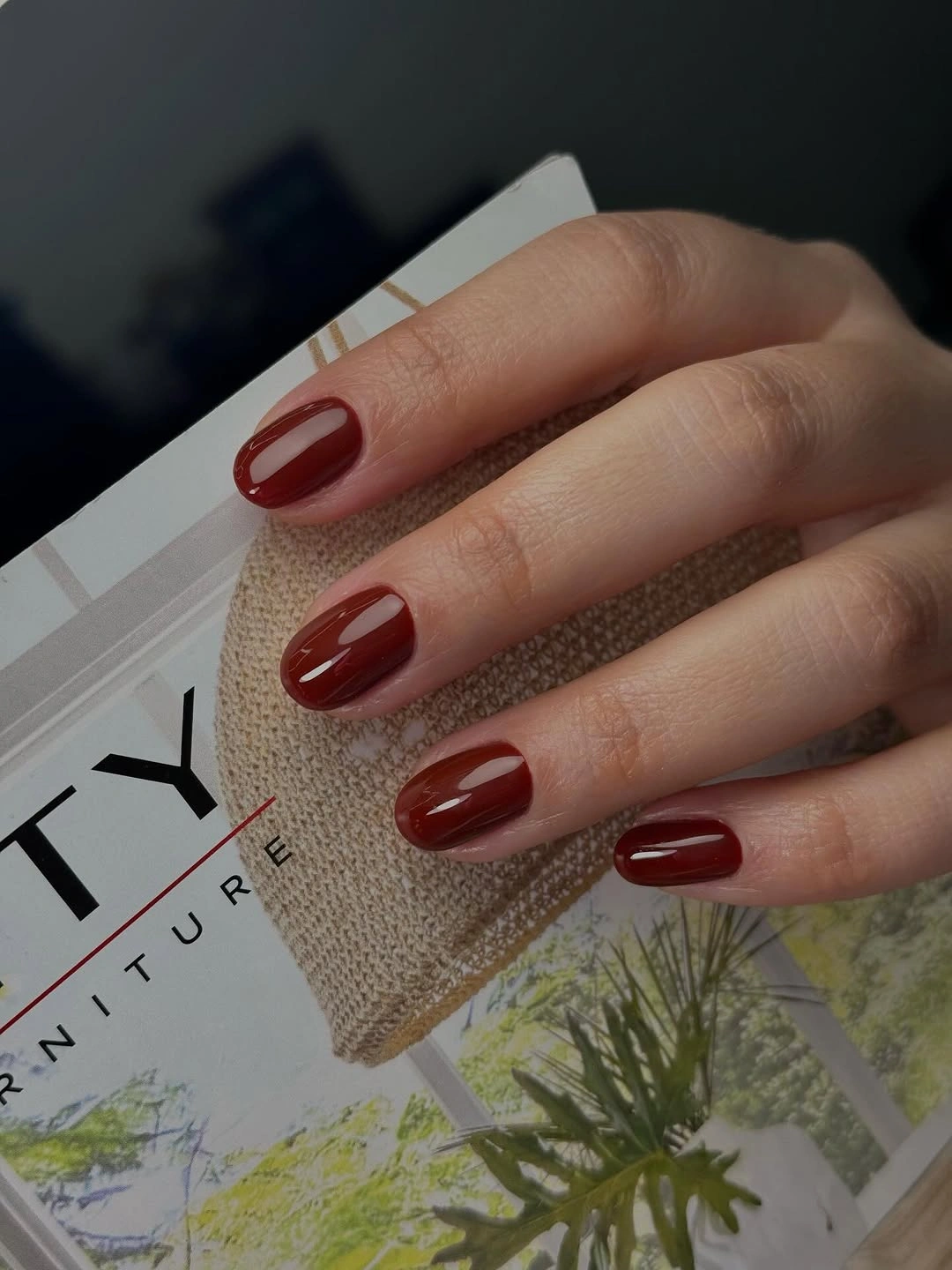 Short rounded-square nails in a glossy deep wine red