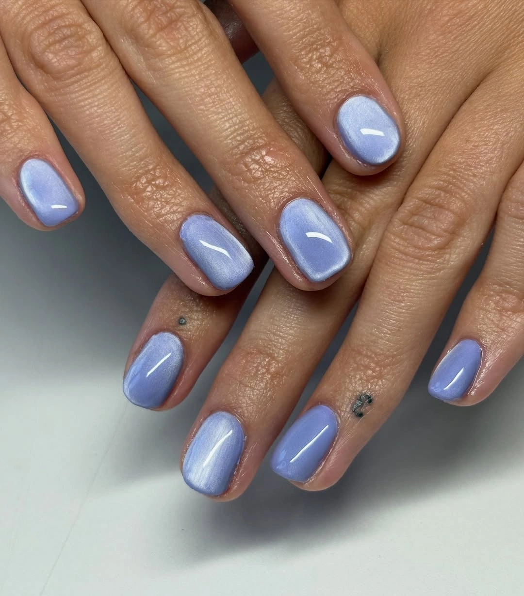 Short rounded-square nails in glossy pastel periwinkle blue