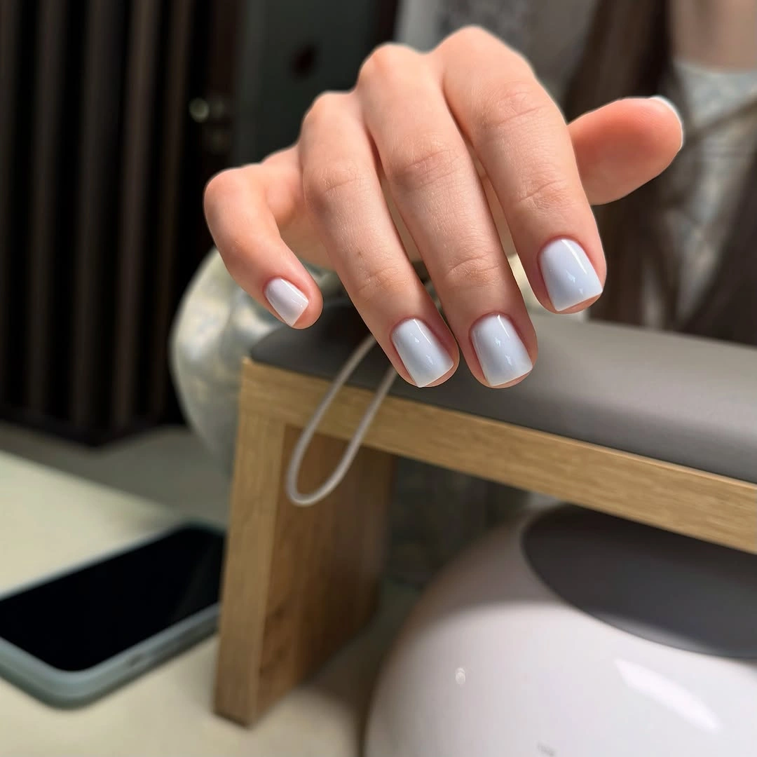 Short square nails painted glossy pale icy blue