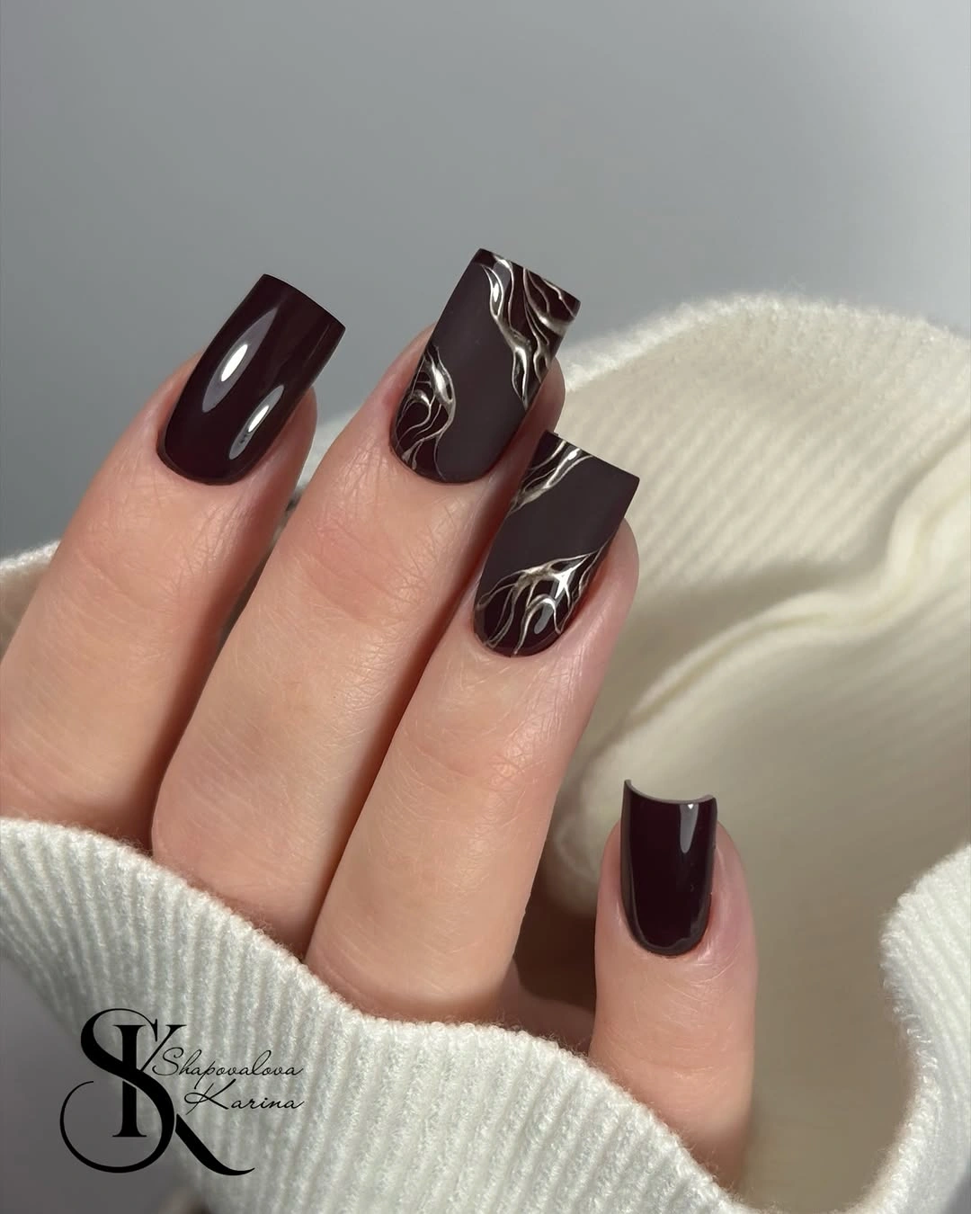 Medium square burgundy nails with black and metallic leaf accents