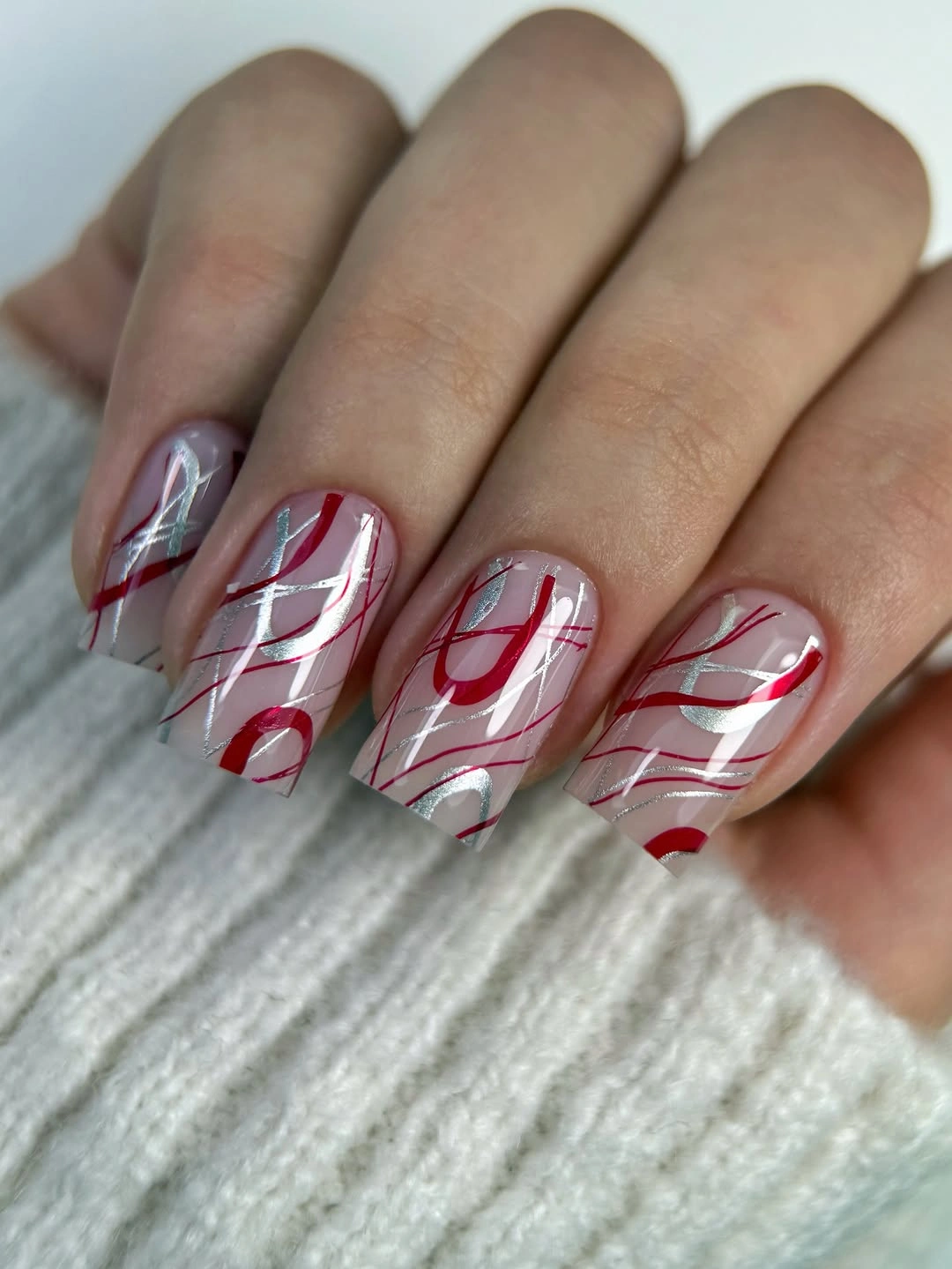 Milky square nails with fine red abstract linework
